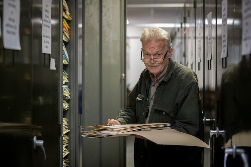 Curator Andrew Sanders holding specimens from the herbarium's large collection of California flora. (Stan Lim/UCR)​